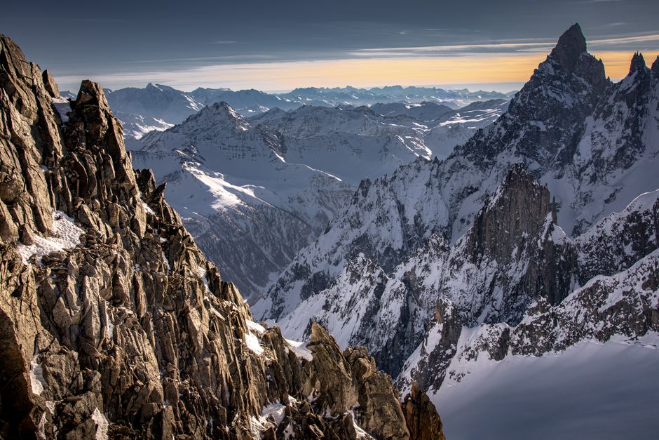 Breathtaking view of snow-covered mountains at sunrise, showcasing rugged terrain.